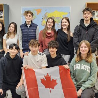 group-of-eleven-international-students-holding-a-canadian-flag