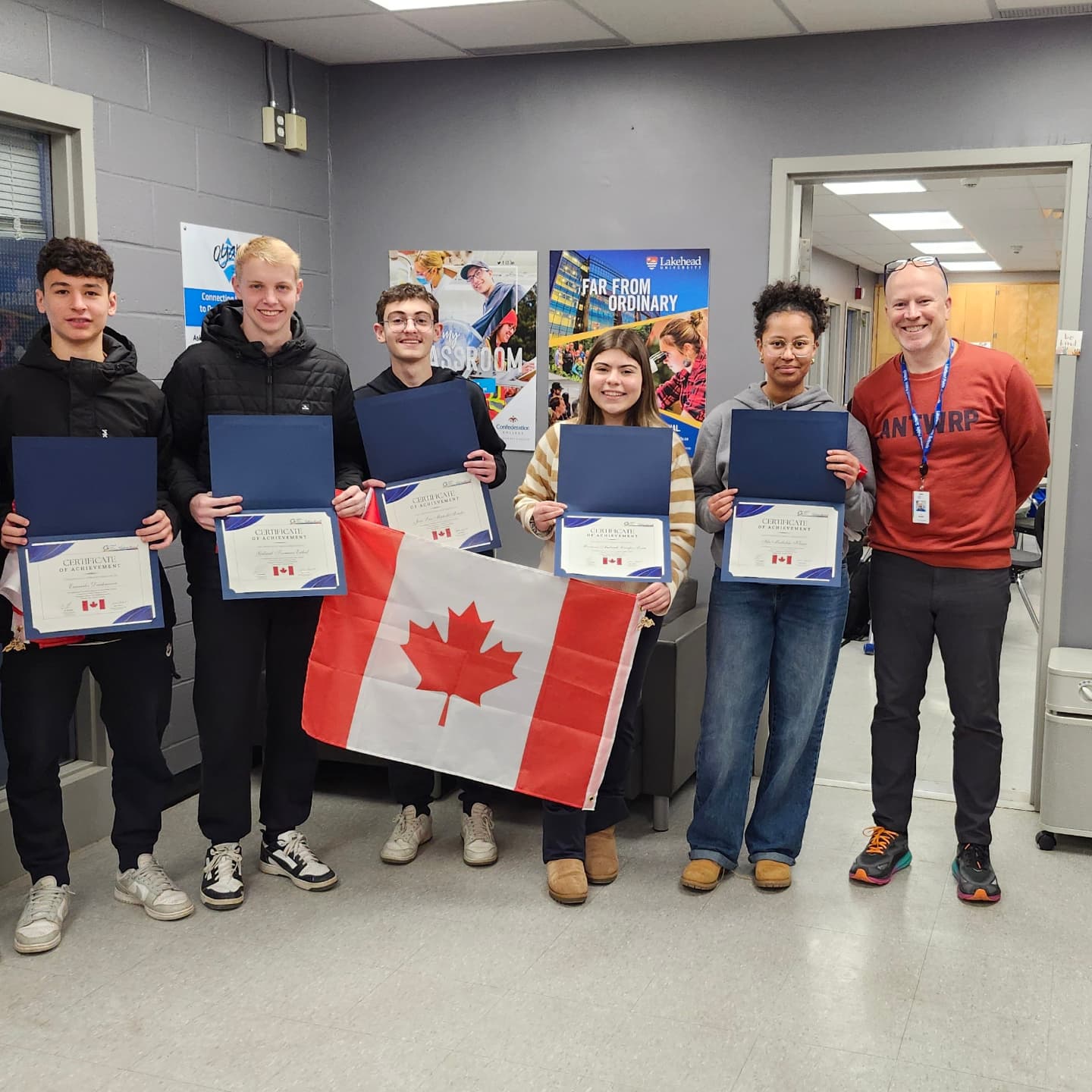 group-of-five-international-students-holding-certificates-and-a-canadian-flag-with-international-coordinator