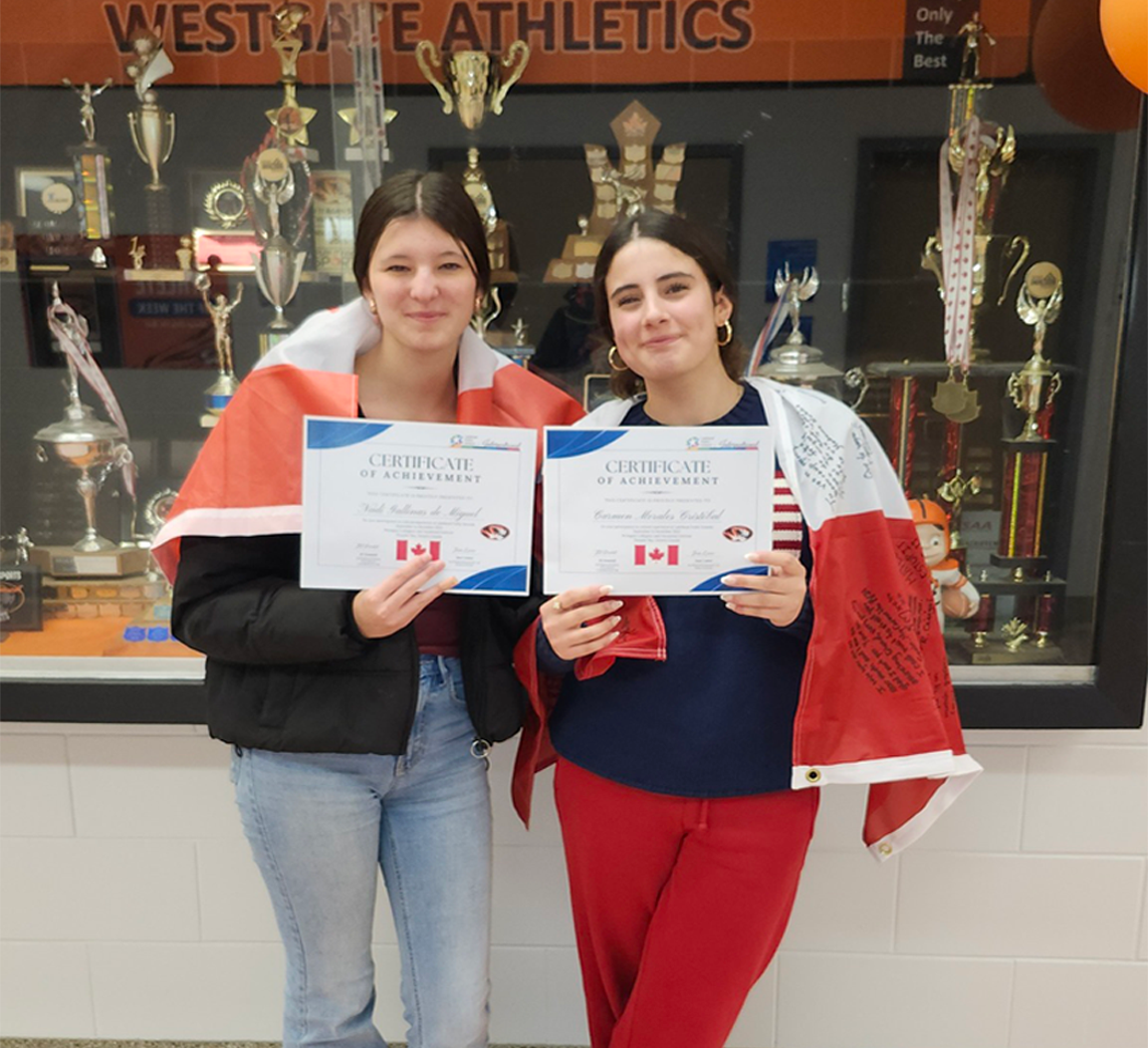 two-international-students-holding-certificates-at-westgate-holding-canada-flag