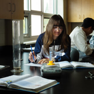 international-student-sitting-at-desk-doing-science-work