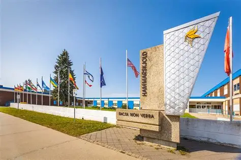 hammarksjold-high-school-from-front-with-school-flags-and-statue