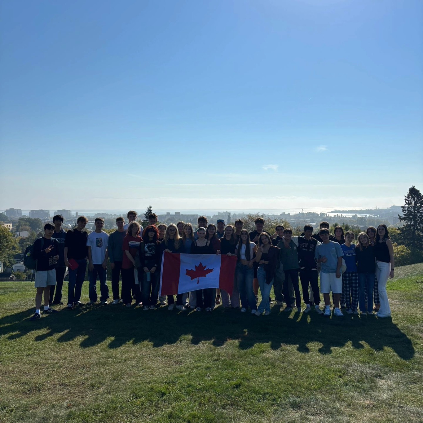 group-of-international-students-at-hillcrest-holding-canada-flag-with-city-and-lake-superior-in-background