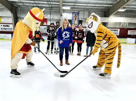 hockey-puck-face-off-hammarskjold-viking-mascot-and-westgate-tiger-with-person-dropping-puck