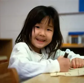 young-girl-drawing-at-table-smiling